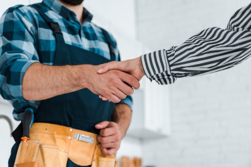 Handshake between an AV technician in work gear and a homeowner after a job