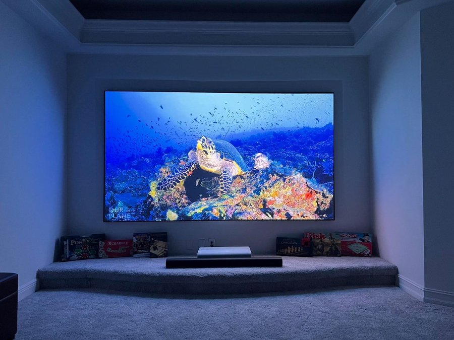 Ultra short throw projector with fixed frame screen in a media room
