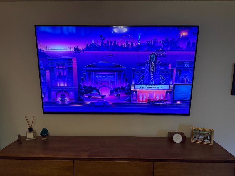 75 inch Roku TV wall mounted in bedroom with concealed wiring